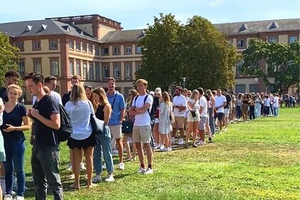 Studierende stehen in einer langen Schlange auf der Mensawiese. Im Hintergrund das Barockschloss Mannheim. Link: Instagram-Post Erstsemester