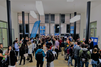 Viele Menschen stehen in einem großen Saal, beim Mentoring Kick Off
