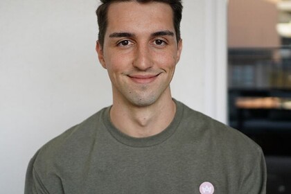 Portrait von Simon Schöbel (dunkle Haare, brauner Pullover).