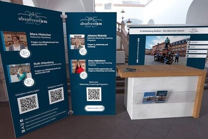 Aufnahme eines Messe-Standes von "Absolventum". Links sind große Aufsteller zu sehen und rechts daneben ein Tisch.