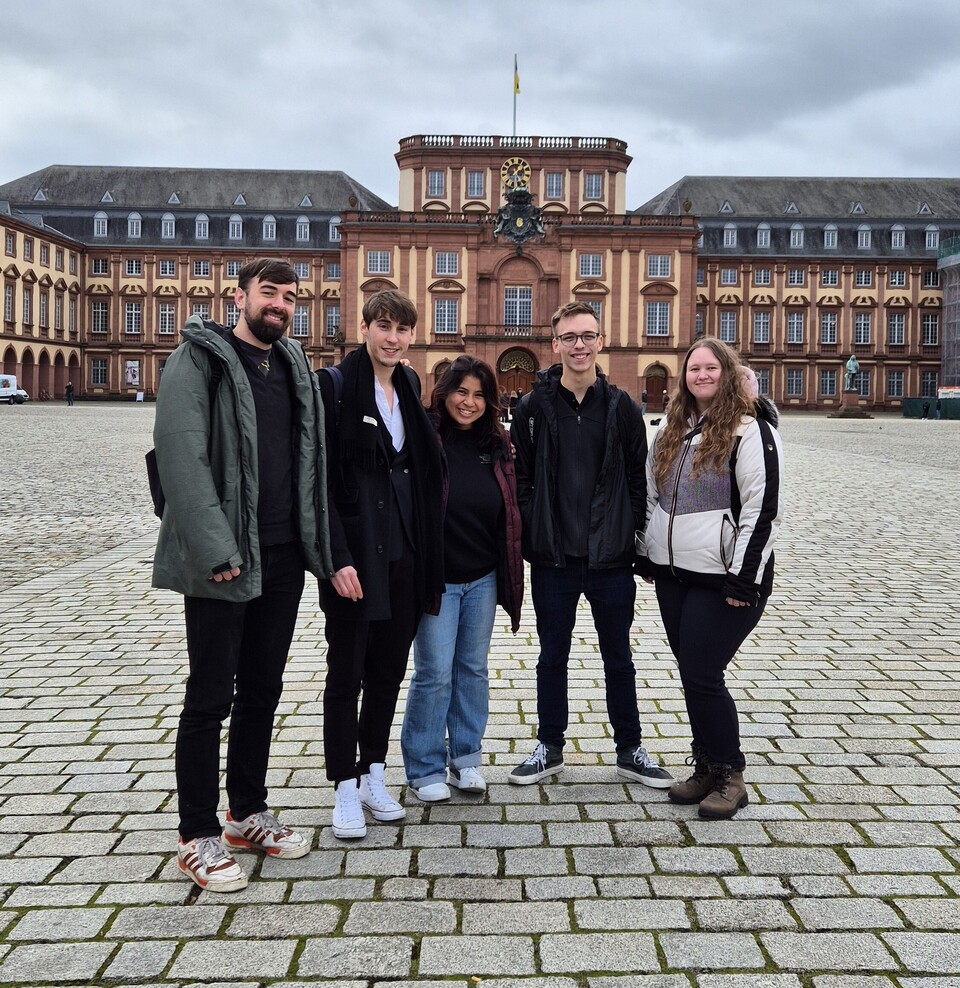 Eine Gruppe Studierender posiert auf dem Ehrenhof