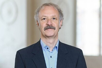 Porträt des BWL-Professors Dr.  Moritz Fleischmann. Der neugewählte Prorektor für Nachhaltigkeit und Informationsversorgung der Universität Mannheim trägt einen dunkelblauen Anzug und ein hellblaues Hemd und einen markanten Schnauzbart. Link: Instagram Prorektor für Nachhaltigkeit und Informationsversorgung