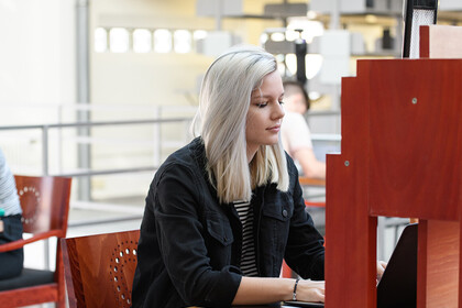 Eine Studentin arbeitet in der A3-Bibliothek an ihrem Laptop. 