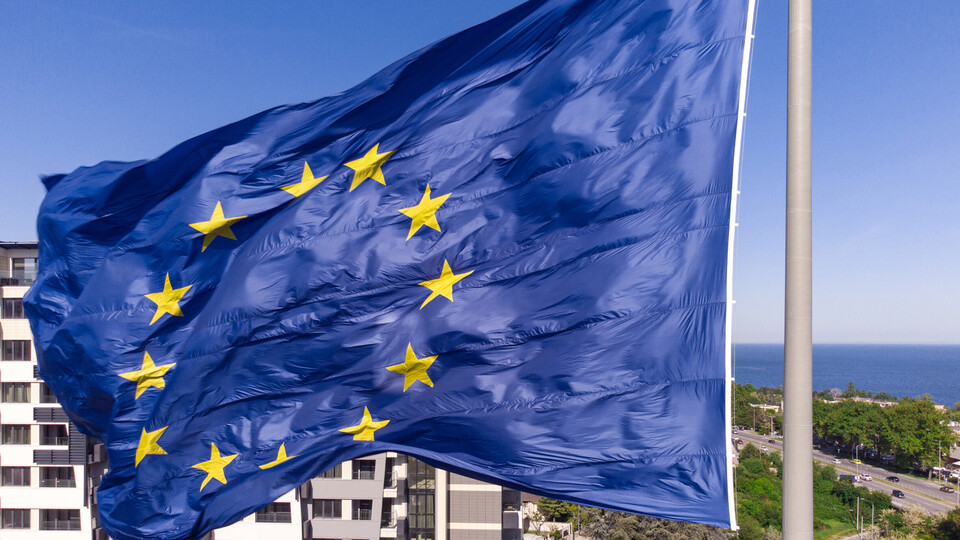 Die Flagge der Europäischen Union weht an einer Fahnenstange im Wind.