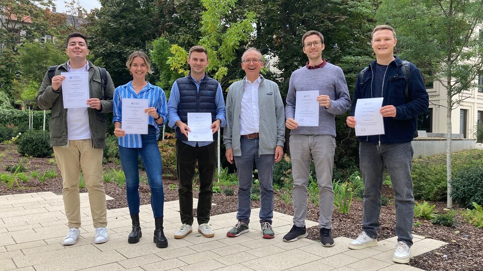 GESS award winners standing in the yard, holding their certificates. From left to right: Pablo Zarate Cisternas, Klara Müller, Clemens Lauer, Prof. Thomas Gschwend, Sven Vahlpahl and Johannes Gaul.