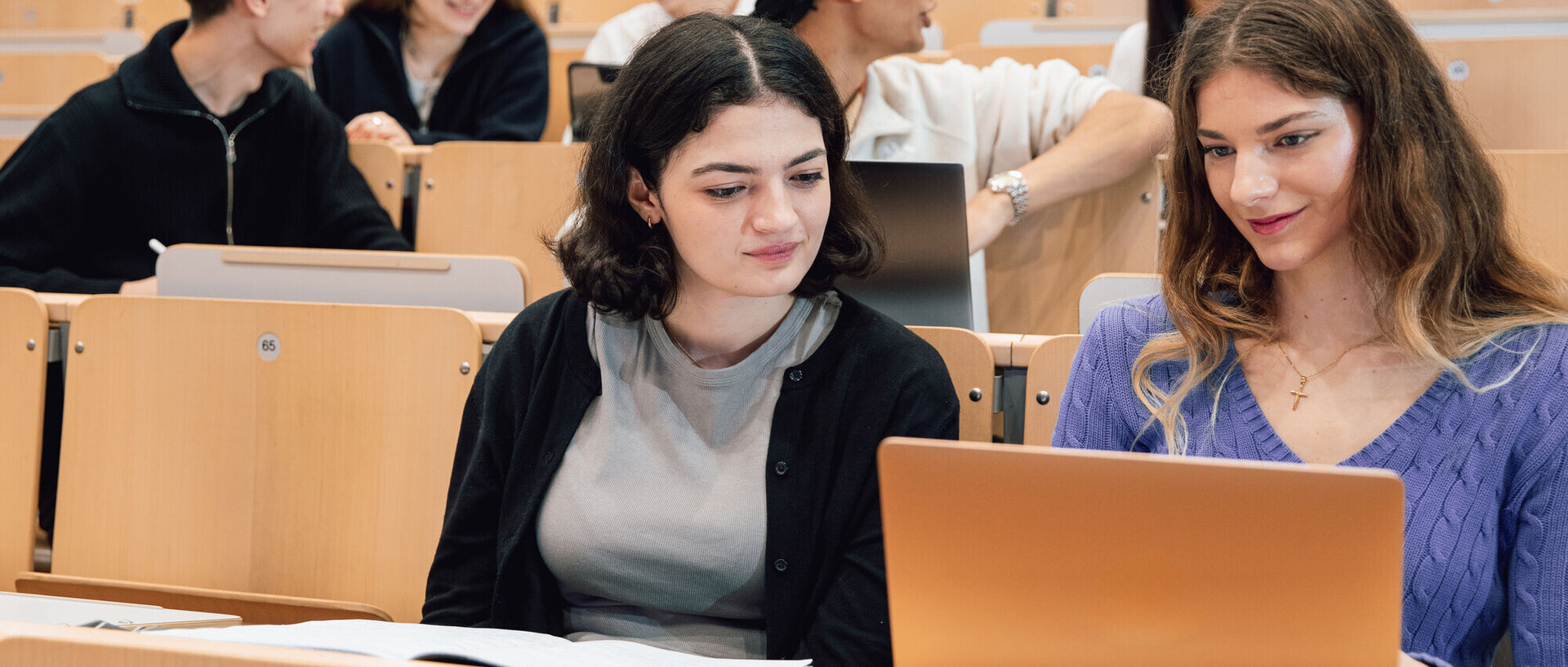 Studierende in einem Hörsaal auf den Rängen.