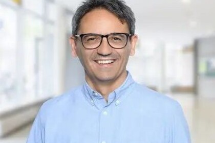 Portrait von Antonio Ciccone. Er trägt eine Brille und ein hellblaues Hemd.
