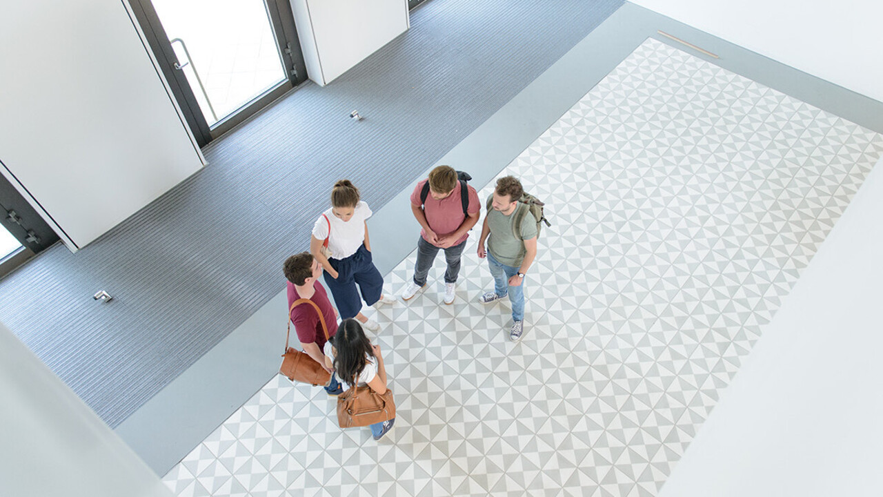 Eine Gruppe Studierender steht im Foyer des B6-Gebäudes.