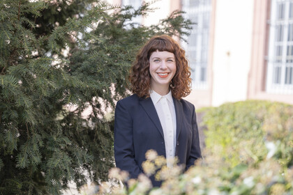 Corinna Kröger. Corinna Kröger lacht freundlich und trägt ein dunkles Jackett.