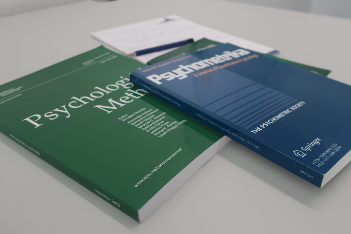 a few scientific journals and a note pad placed on a table