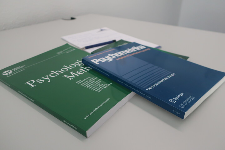 a few scientific journals and a note pad placed on a table