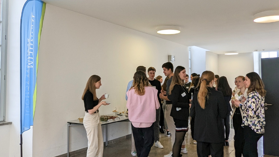 Studierende am Networken und Häppchen essen