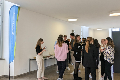 Studierende am Networken und Häppchen essen