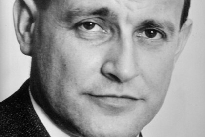 Schwarz-weiß Portrait von Knut Borchardt. Er trägt ein weißes Hemd, eine dunkle Krawatte sowie einen dunklen Blazer.