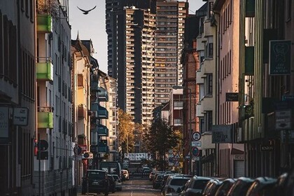 Straße in den Mannheimer Quadraten. Am Ende ragt einer der Wohntürme der Neckarpromenade wie ein Wolkenkratzer in den Himmel. Link: Instagram Wolkenkratzer in Mannheim