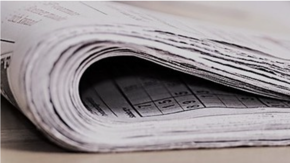 Eine Zeitung ist halb gefallen und liegt auf einer Oberfläche.