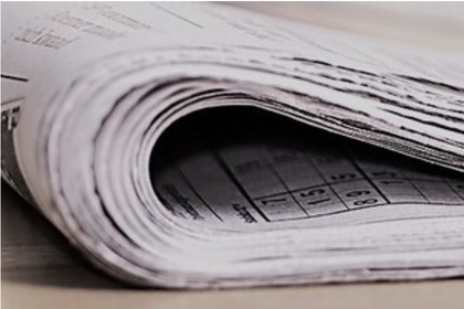 Eine Zeitung ist halb gefallen und liegt auf einer Oberfläche.