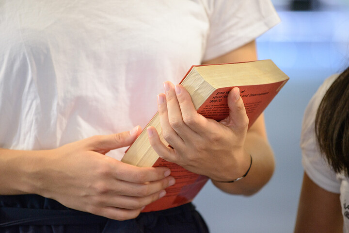 Jemand hält ein Buch in den Händen. 
