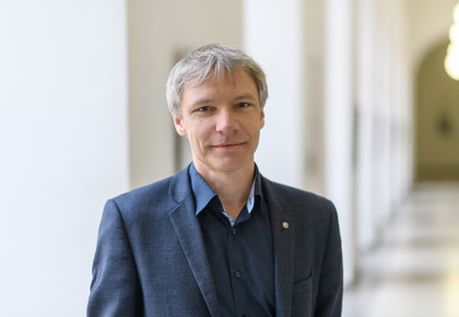 Stefan Münzer hat kurze graue Haare. Er trägt ein blaues Hemd und ein blaues Jacket.