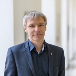 Stefan Münzer hat kurze graue Haare. Er trägt ein blaues Hemd und ein blaues Jacket.