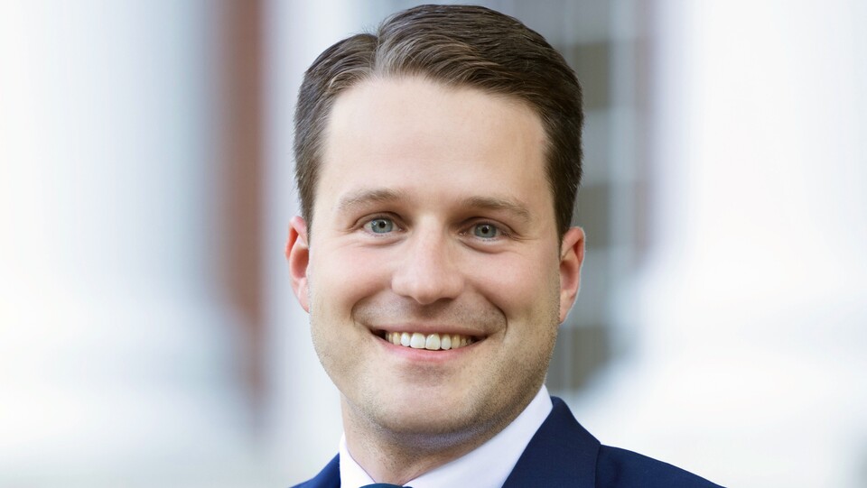 Gunther Glenk hat kurze Haare und trägt einen dunkelblauen Anzug und eine Krawatte