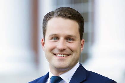 Gunther Glenk hat kurze Haare und trägt einen dunkelblauen Anzug und eine Krawatte