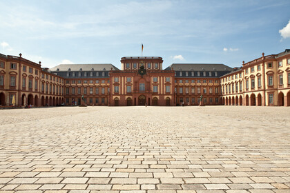 Das Mannheimer Barockschloss und der Ehrenhof unter blauem Himmel.