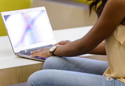 Eine Studentin meldet sich an ihrem Laptop an.