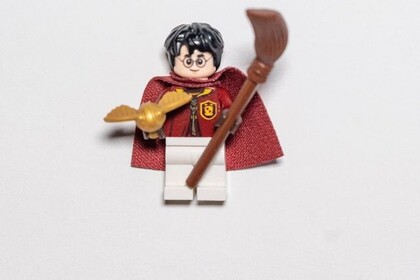 In der Mitte ist eine Harry-Potter-Figur mit rotem Umhang und weißer Hose zu sehen. Die Figur hält einen Besen und einen goldenen Schnatz in der Hand und hat schwarze Haare. Unten rechts ist das Logo des IFS- Institut für Sport der Universität Mannheim.