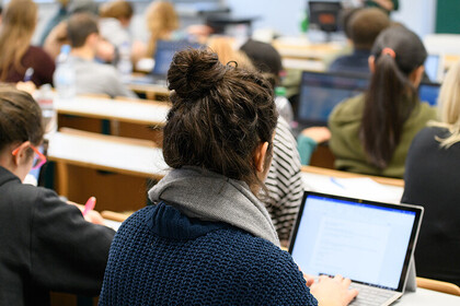 Mehrere Studierende sitzen in einem Hörsaal. 