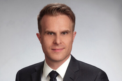 Prof. Stahl hat kurze Haare und trägt Anzug und Krawatte.