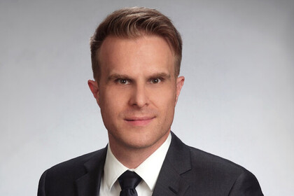 Prof. Stahl hat kurze Haare und trägt Anzug und Krawatte.