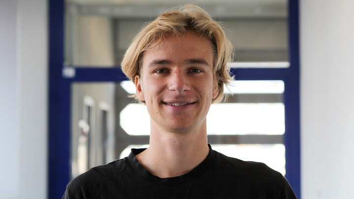 Porträt von Oliver Rittmann. Er hat blonde Haare und trägt ein schwarzes T-shirt.