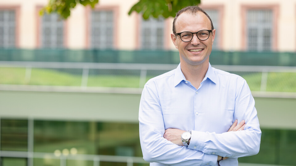 Porträtbild von Professor Moritz Kuhn. Er trägt ein Hemd und eine Brille.