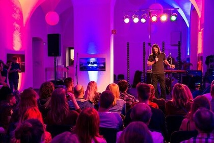 Blick auf einen Musizierenden mit Publikum.