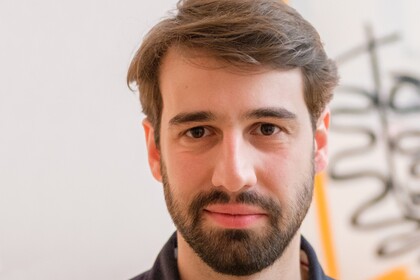 Portrait von Cornelius Schneider. Er trägt ein schwarzes Hemd. 