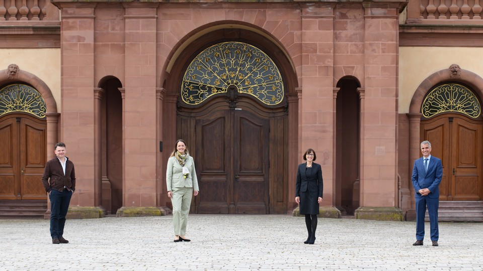 Vier Personen stehen im Innenhof des Mannheimer Schlosses.
