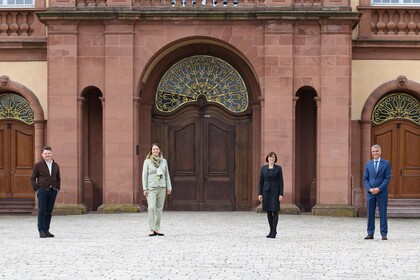 Vier Personen stehen im Innenhof des Mannheimer Schlosses.