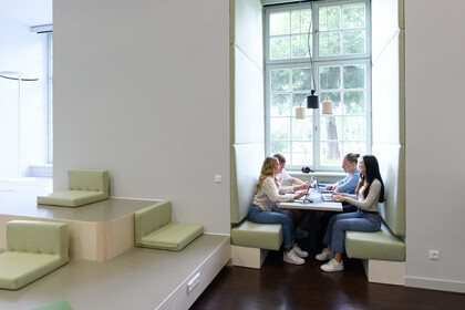 Vier Studierende sitzen in einer Lernnische. 