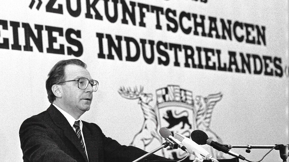 Historisches Foto in schwarz-weiß, das Lothar Spät auf einem Podium zeigt. Im Hintergrund steht: Kongress "Zukunftschancen eines Industrielandes"