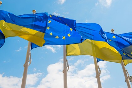 Die Flaggen der Ukraine und der EU wehen nebeneinander im Wind.