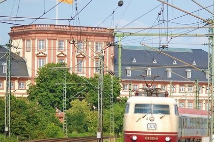 Blick auf einen Zug, der an der Universität Mannheim vorbeifährt. 