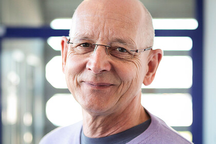 Portrait von Rüdiger Schmitt-Beck. Er trägt einen hell-lilafarbenen Pullover. 