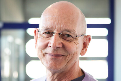 Portrait von Rüdiger Schmitt-Beck. Er trägt einen hell-lilafarbenen Pullover. 