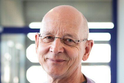 Portrait von Rüdiger Schmitt-Beck. Er trägt einen hell-lilafarbenen Pullover. 