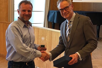 Dekan Lutz schüttelt Prof. Ruenzi die Hand und übergibt einen Preis