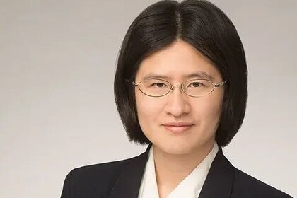 Yanghua Shi hat schwarze kinnlange Haare. Sie trägt eine feine Brille, einen dunklen Blazer und ein weißes Hemd.