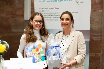 Zwei Frauen halten ein Geschenk und ein Zertifikat in den Händen. 