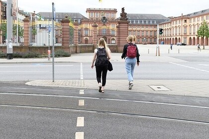 Zwei Studierende überqueren die Straße Richtung Universität Mannheim.