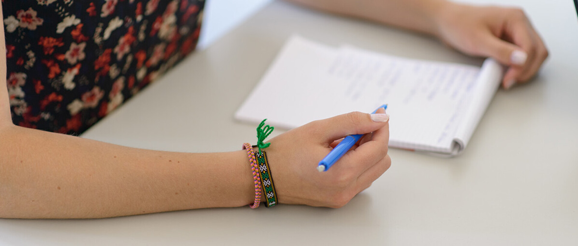 Person schreibt auf ein Blattpapier.
